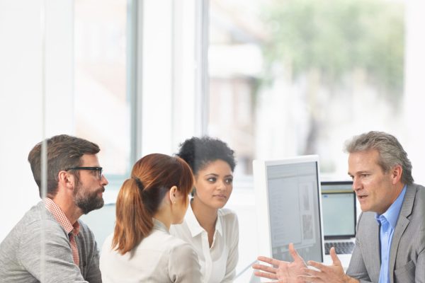 Laying down his ideas. A group of businesspeople going over some plans together